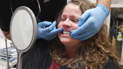 Take 2 Dental Implant Studio patient checking out her new dental implants