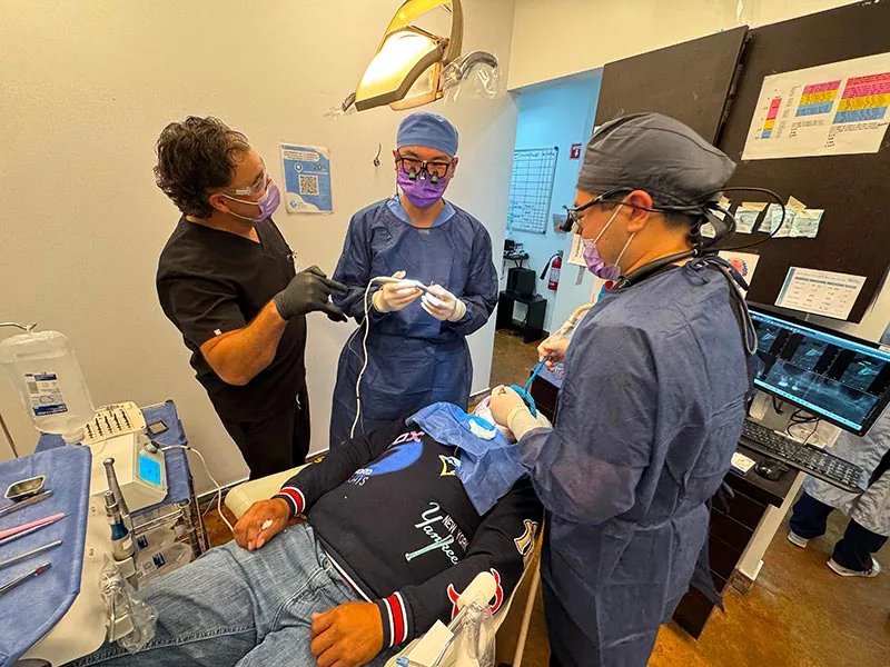 Dentists treating a patient during implant training course